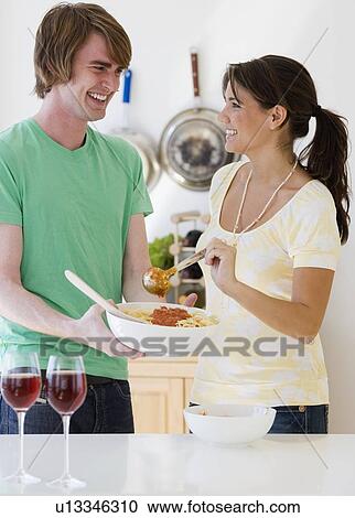 Stock Image - Couple preparing food in kitchen. Fotosearch