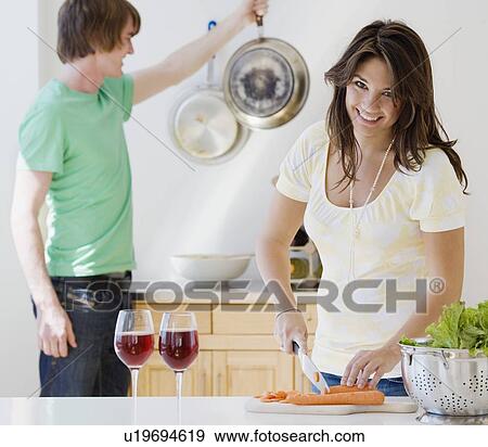 Couple preparing food in kitchen View Large Photo Image Stock Photo - Couple preparing food in kitchen. Fotosearch