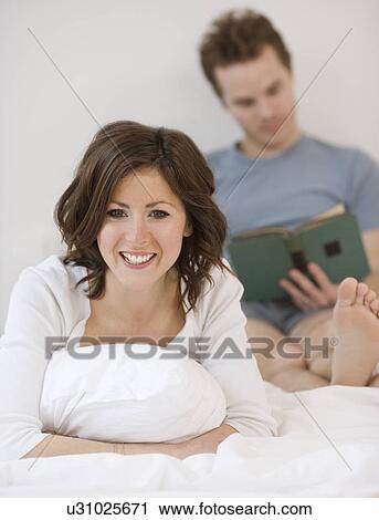 Couple relaxing in bed View Large Photo Image Stock Image - Couple relaxing in bed. Fotosearch