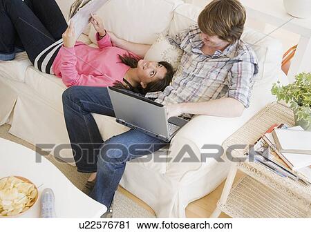 Couple relaxing on sofa View Large Photo Image Stock Image - Couple relaxing on sofa. Fotosearch