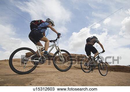 Couple riding mountain bikes in desert View Large Photo Image Stock Image - Couple riding mountain bikes in desert. Fotosearch