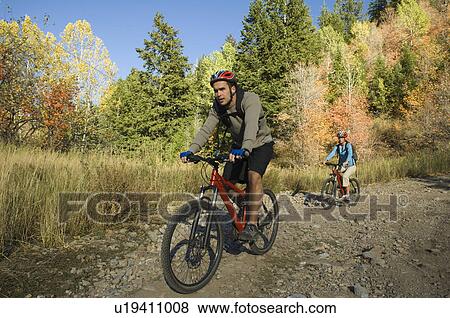 Stock Photo - Couple riding mountain bikes, Utah, United States. Fotosearch