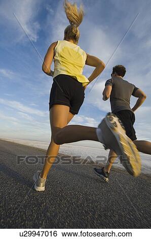 Couple running on road, Utah, United States View Large Photo Image Stock Photograph - Couple running on road, Utah, United States. Fotosearch