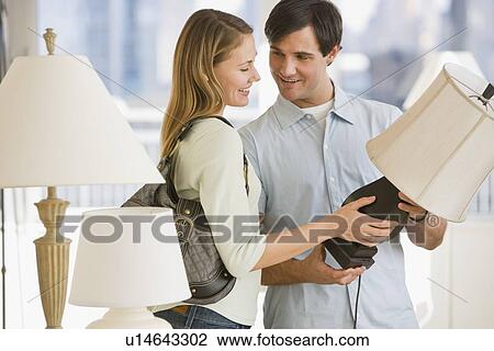 Stock Image - Couple shopping for lighting. Fotosearch