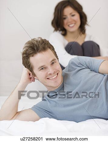 Couple sitting in bed View Large Photo Image Stock Image - Couple sitting in bed. Fotosearch