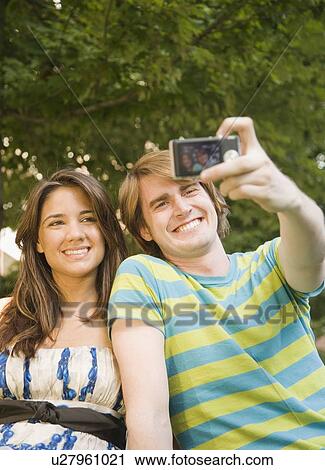 Stock Image - Couple taking own photograph. Fotosearch
