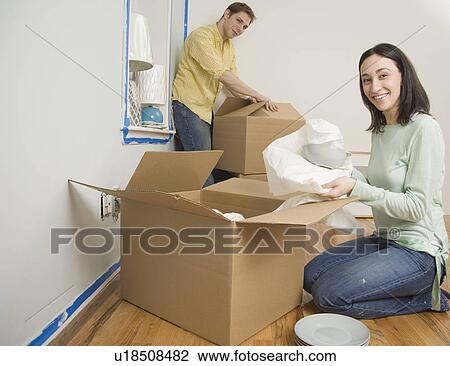 Couple unpacking boxes in new house View Large Photo Image Stock Image - Couple unpacking boxes in new house. Fotosearch