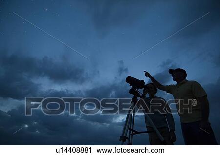 Couple using telescope on tripod View Large Photo Image Stock Image - Couple using telescope on tripod. Fotosearch
