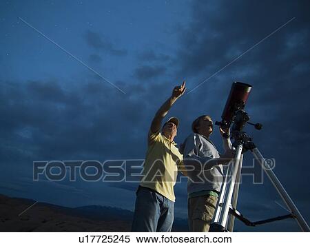 Couple using telescope on tripod View Large Photo Image Stock Photography - Couple using telescope on tripod. Fotosearch