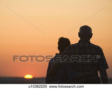 Couple watching sunset View Large Photo Image Stock Photography - Couple watching sunset. Fotosearch