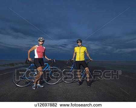 Stock Image - Couple with bicycles on road, Utah, United States. Fotosearch