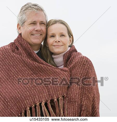 Stock Photography - Couple wrapped in blanket. Fotosearch