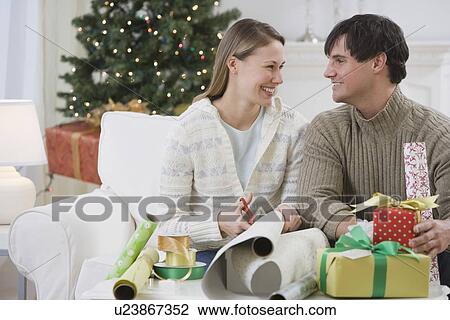 Couple wrapping Christmas gifts View Large Photo Image Stock Image - Couple wrapping Christmas gifts. Fotosearch
