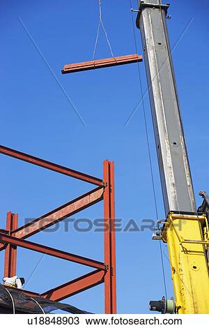 Stock Image - Crane holding steel girder. Fotosearch