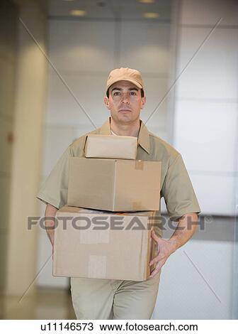 Delivery man carrying stack of packages View Large Photo Image Stock Image - Delivery man carrying stack of packages. Fotosearch