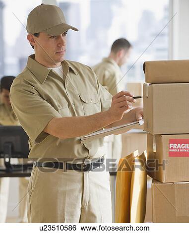 Stock Photograph - Delivery man making package. Fotosearch