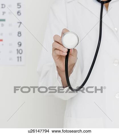 Doctor holding stethoscope View Large Photo Image Picture - Doctor holding stethoscope. Fotosearch