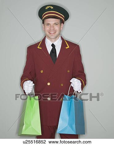 Doorman holding shopping bags View Large Photo Image Stock Image - Doorman holding shopping bags. Fotosearch