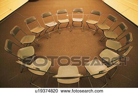 Stock Image - Empty folding chairs in circle. Fotosearch