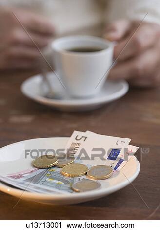 Stock Image - Euros on plate at cafe. Fotosearch