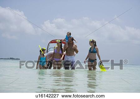 Stock Photo - Family with snorkeling gear walking in water, Florida, United States. Fotosearch