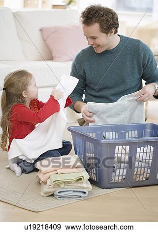 Father and daughter folding laundry View Large Photo Image Stock Photo - Father and daughter folding laundry. Fotosearch