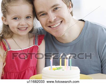 Stock Image - Father and daughter with birthday cake. Fotosearch