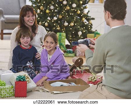 Stock Image - Father video recording family on Christmas. Fotosearch