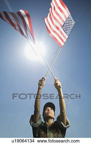 Female army soldier holding American flags View Large Photo Image Picture - Female army soldier holding American flags. Fotosearch