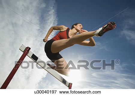 Female athlete jumping hurdle, Utah, United States View Large Photo Image Stock Photo - Female athlete jumping hurdle, Utah, United States. Fotosearch