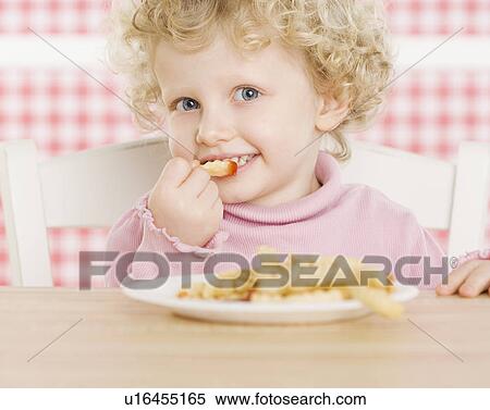 Stock Photography - Female child eating French fries. Fotosearch
