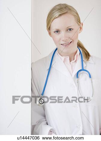Stock Photograph - Female doctor leaning on wall. Fotosearch