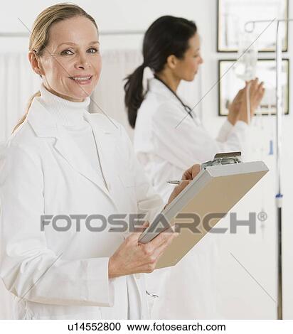 Female doctor writing on chart View Large Photo Image Stock Image - Female doctor writing on chart. Fotosearch