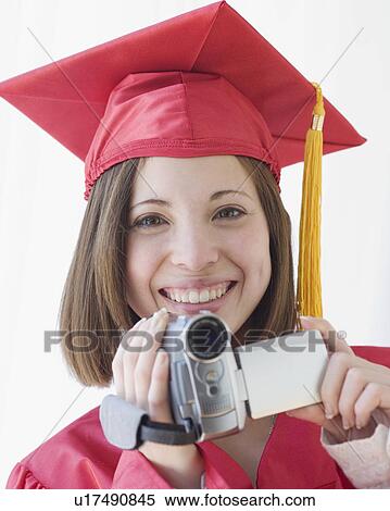 Female graduate holding video camera View Large Photo Image Stock Photography - Female graduate holding video camera. Fotosearch