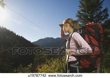 Stock Image - Female hiker shielding eyes with hand, Utah, United States. Fotosearch