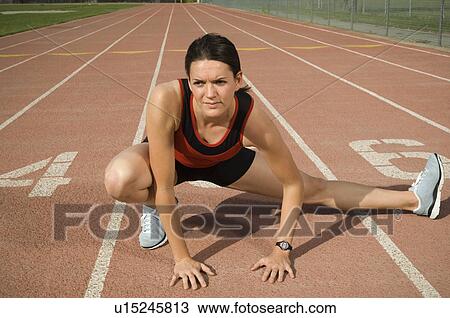 Stock Image - Female runner stretching, Utah, United States. Fotosearch