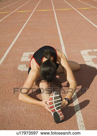 Stock Photo - Female runner stretching, Utah, United States. Fotosearch