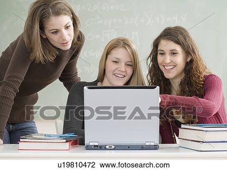 Stock Image - Female students looking at laptop. Fotosearch