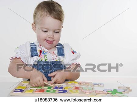 Female toddler playing with a puzzle View Large Photo Image Stock Photograph - Female toddler playing with a puzzle. Fotosearch