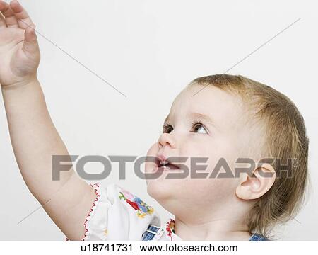 Stock Image - Female toddler reaching up. Fotosearch