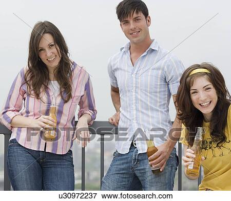 Friends drinking beer at party View Large Photo Image Stock Photo - Friends drinking beer at party. Fotosearch