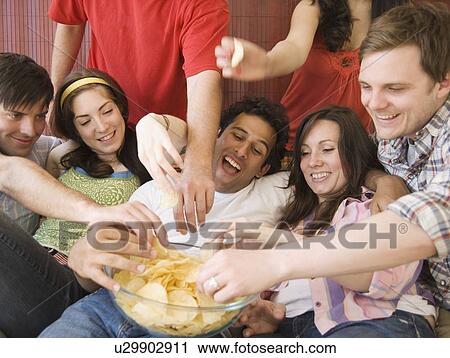 Stock Image - Friends eating chips. Fotosearch