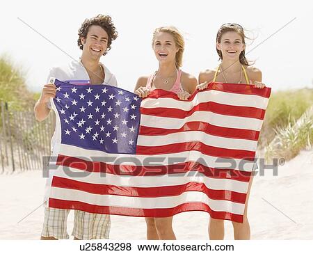 Friends holding American flag View Large Photo Image Stock Photo - Friends holding American flag. Fotosearch