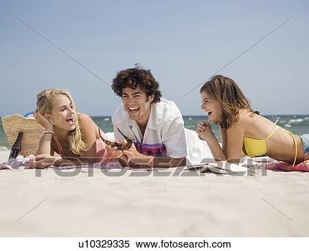 Stock Photography - Friends laughing at beach. Fotosearch