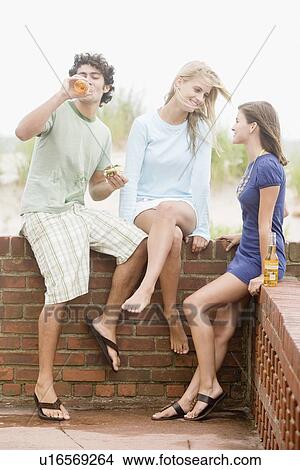 Friends leaning on brick wall View Large Photo Image Picture - Friends leaning on brick wall. Fotosearch