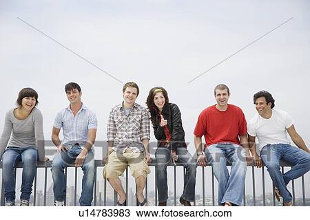 Friends sitting on railing View Large Photo Image Stock Image - Friends sitting on railing. Fotosearch