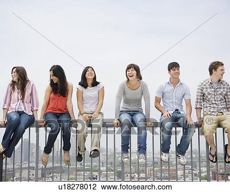 Friends sitting on railing View Large Photo Image Stock Image - Friends sitting on railing. Fotosearch