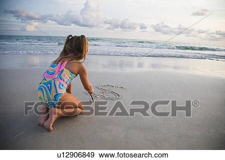 Girl drawing dollar sign in sand, Florida, United States View Large Photo Image Stock Photo - Girl drawing dollar sign in sand, Florida, United States. Fotosearch