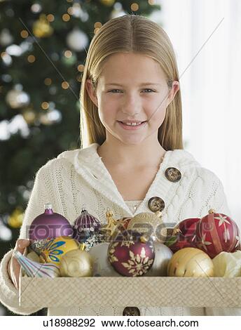 Girl holding box of Christmas ornaments View Large Photo Image Stock Image - Girl holding box of Christmas ornaments. Fotosearch