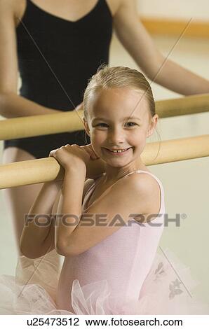 Stock Image - Girl holding on to ballet bar. Fotosearch